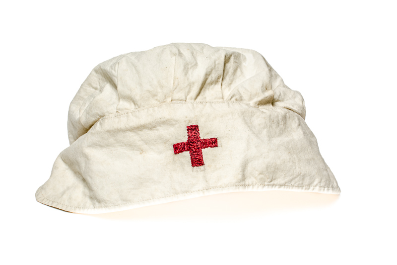 Czepek pielęgniarski, z ręcznie wyszytym czerwonym krzyżem, należący do Zofii Jadwigi Jarzyny (1923-2004), sanitariuszki na terenie obozu Dulag 121. Zbiory Muzeum Dulag 121 - dar Krystyny Zofii Koziatek.